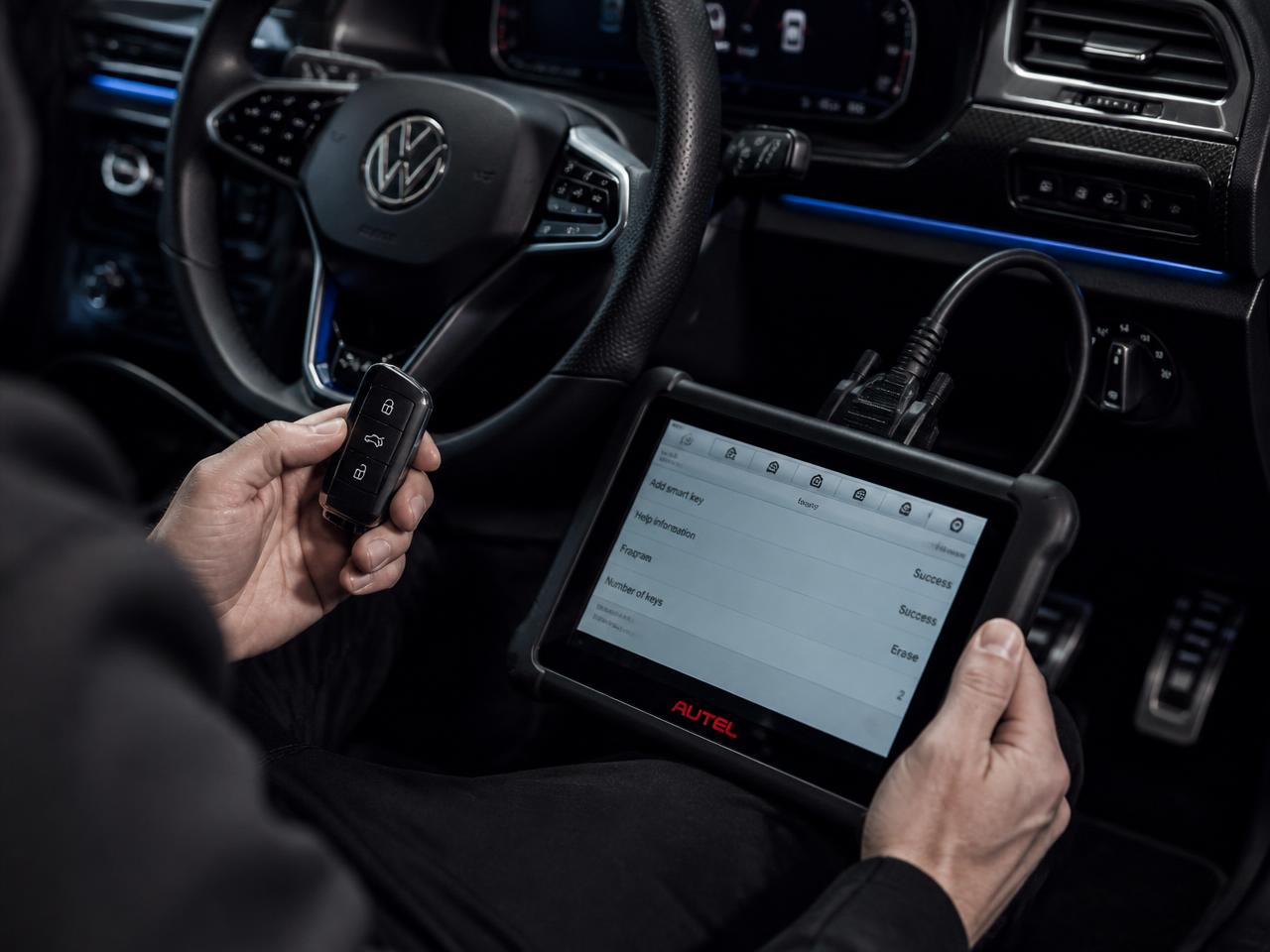 Auto locksmith programming a smart key with diagnostic equipment in a modern European car